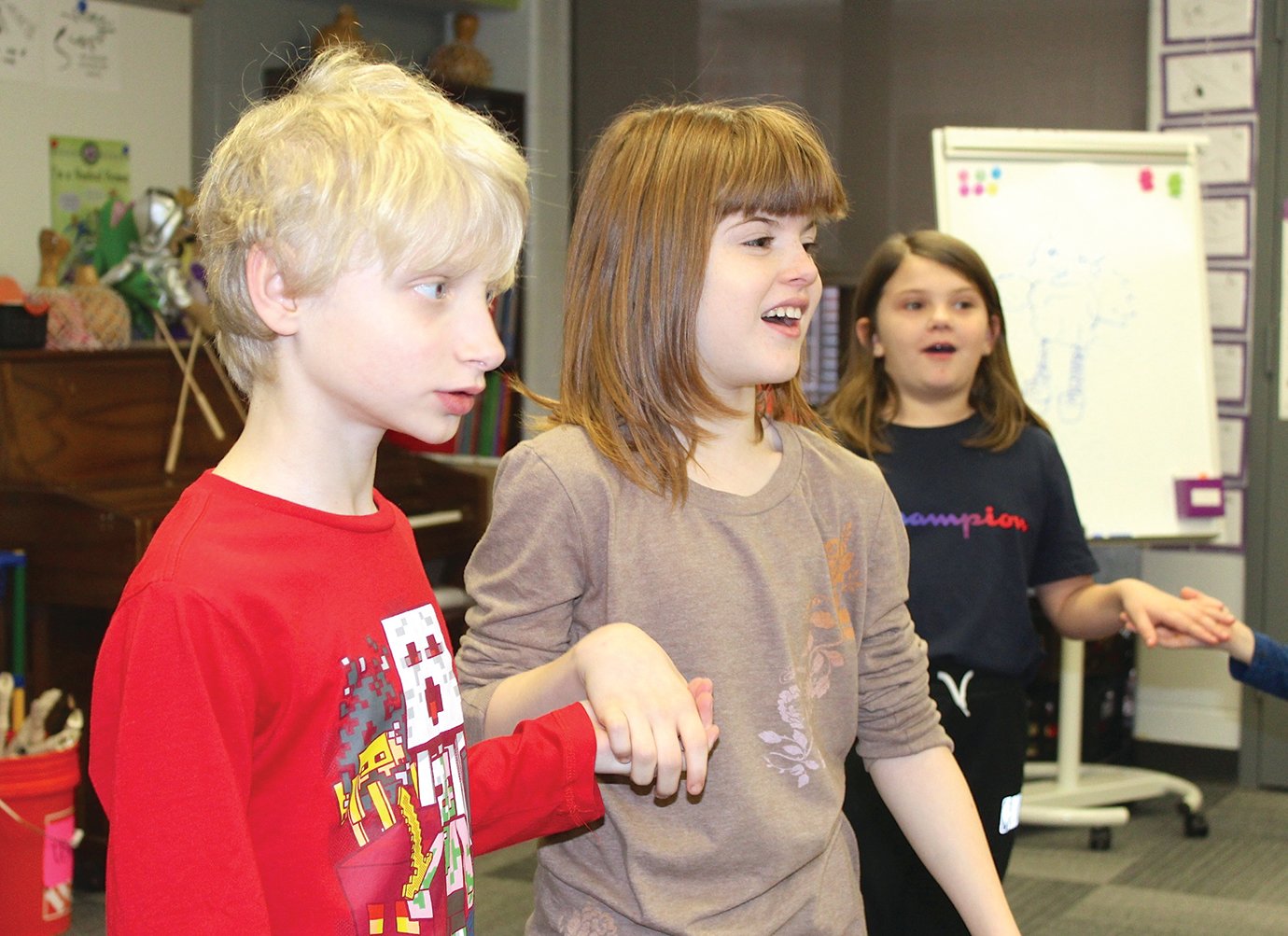 Carson Chandler, left, and dancing partner Cheyenne Parr look to their teacher for the next dance move during music class.