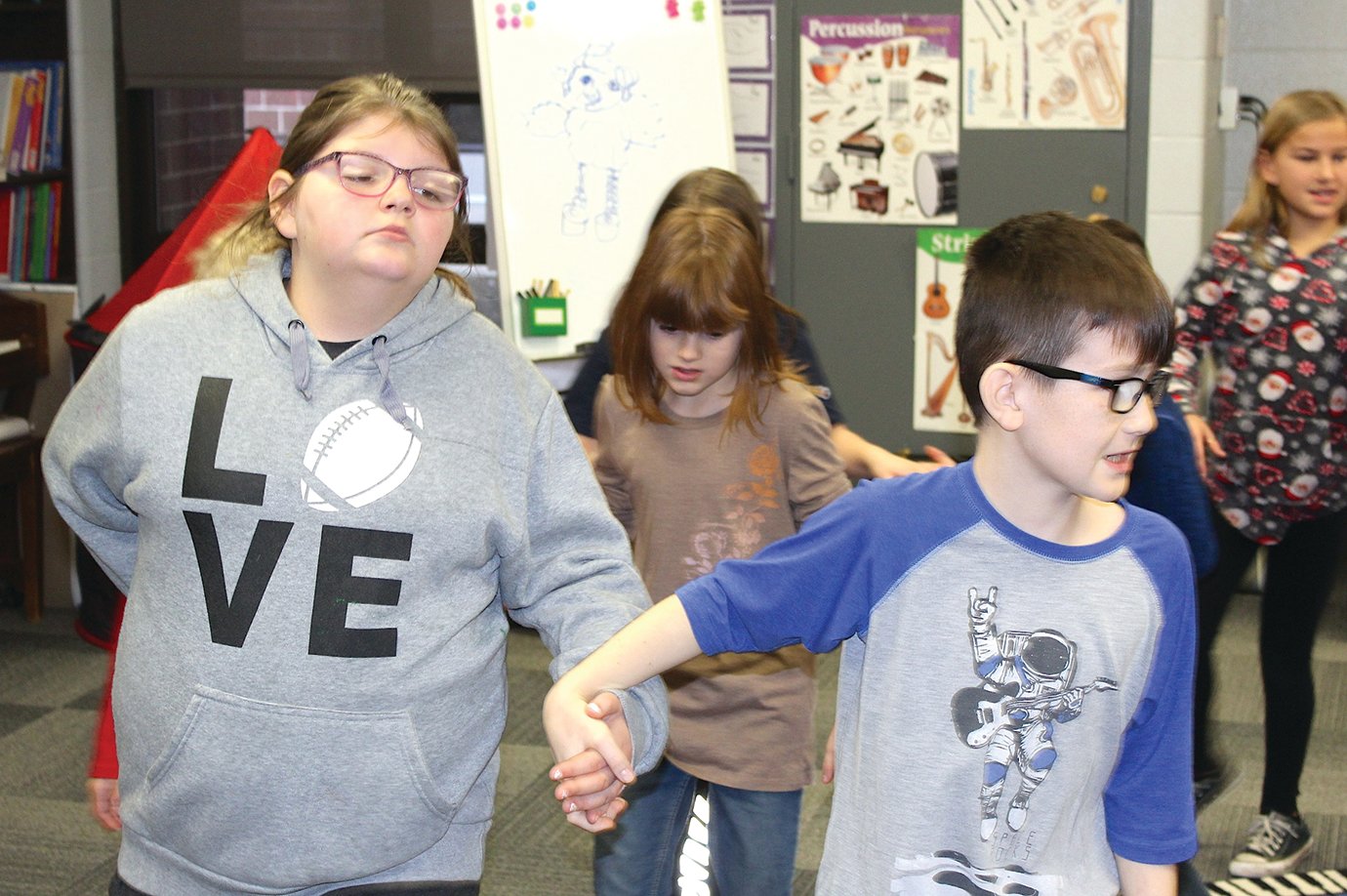 Chloee Sessum, left, and Dawson Jones make their way around a folk-style dancing circle during Jennifer Ellingwood's music class at Ladoga Elementary.