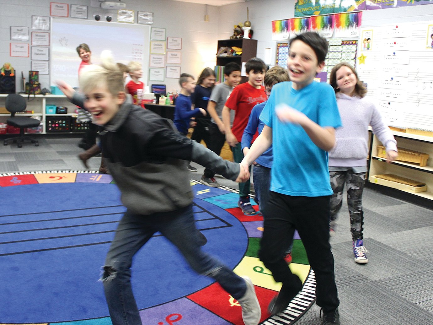 Collyn Stewart, left, and Jackson Brown run around the dancing circle Thursday in Jennifer Ellingwood's Ladoga Elementary music class as the music rapdily increases.