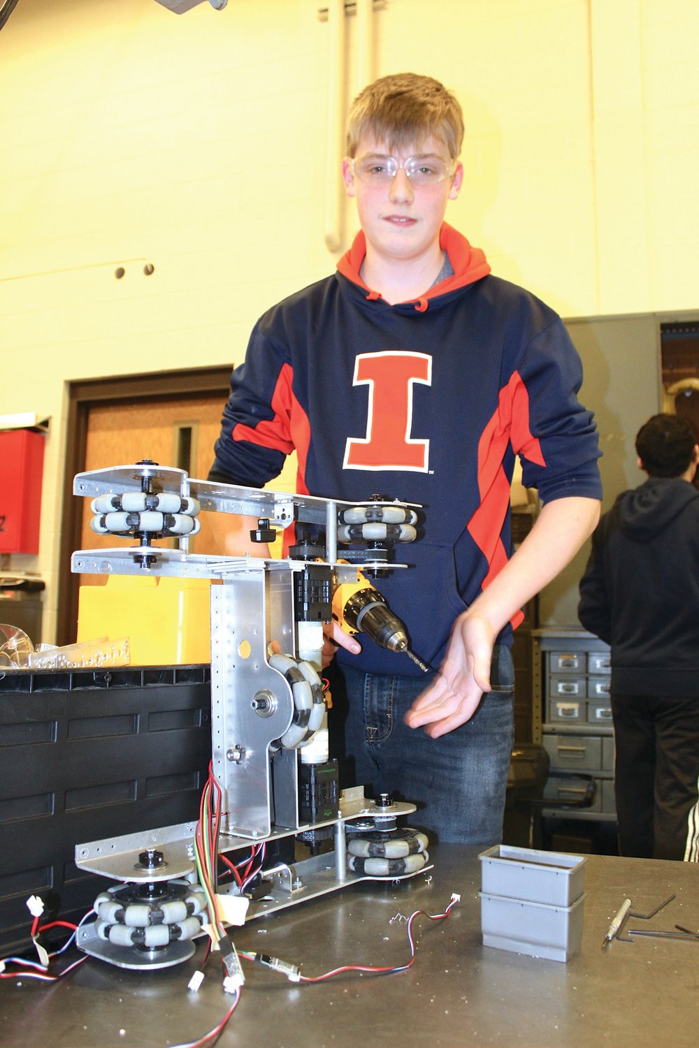 Freshman Christian Campbell, a member of Radical Change robotics team, tinkers with the chassis of a motorized robot.