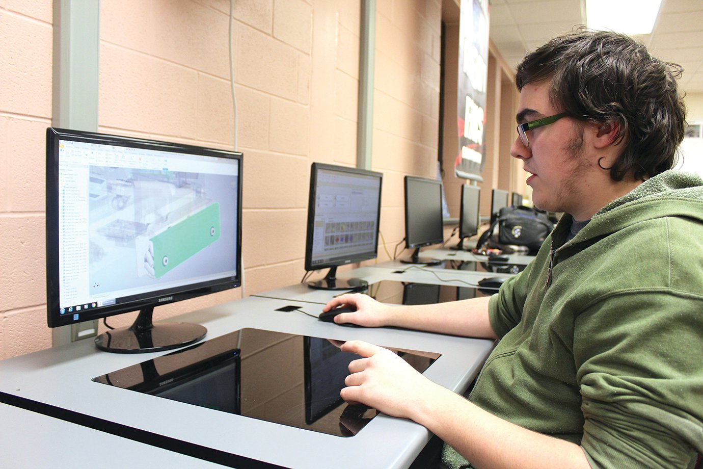 Using a 3D modeling program on one of the many Samsung computers available for the robitics club at Crawfordsville High School, Tayden Morgan strips layers off of the TOBOR robot ("robot" spelled backward) to show the many facets of his team's design.