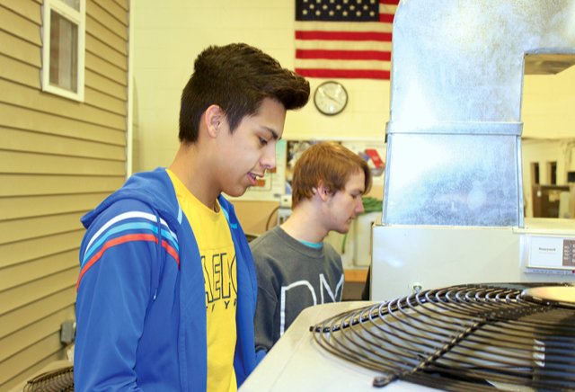 HVAC students James Tinoco, left, and Alex Brown prepare to move an air conditioning unit Friday at Crawfordsville High School.