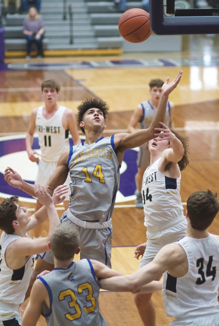 Crawfordsville's Jesse Hall reaches for a loose ball. The junior led the Athenians with 23 points in an 81-80 win over Tri-West in the sectional opener.