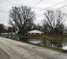 Standing water is shown near a residence in Mace.