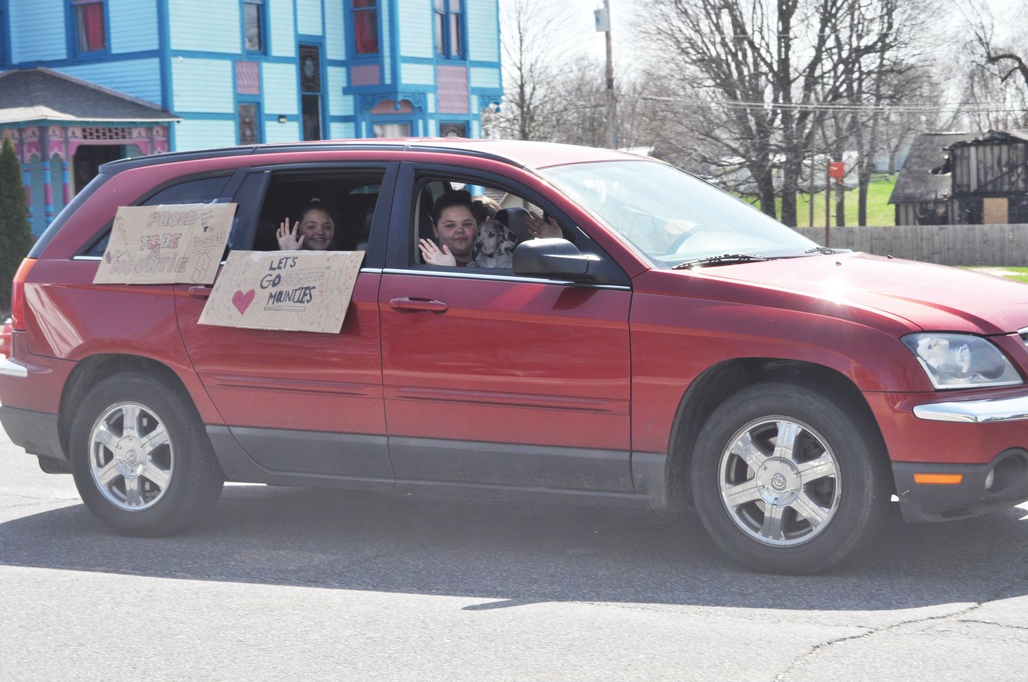 Students wave from the Mountie March route Thursday in downtown Ladoga.