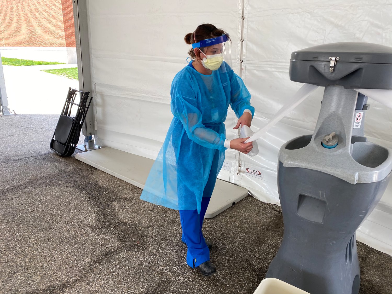 Megan Ellingwood, a certified medical assistant at Franciscan Health, disinfects after conducting a COVID-19 test at the drive-thru testing site at Crawfordsville High School.