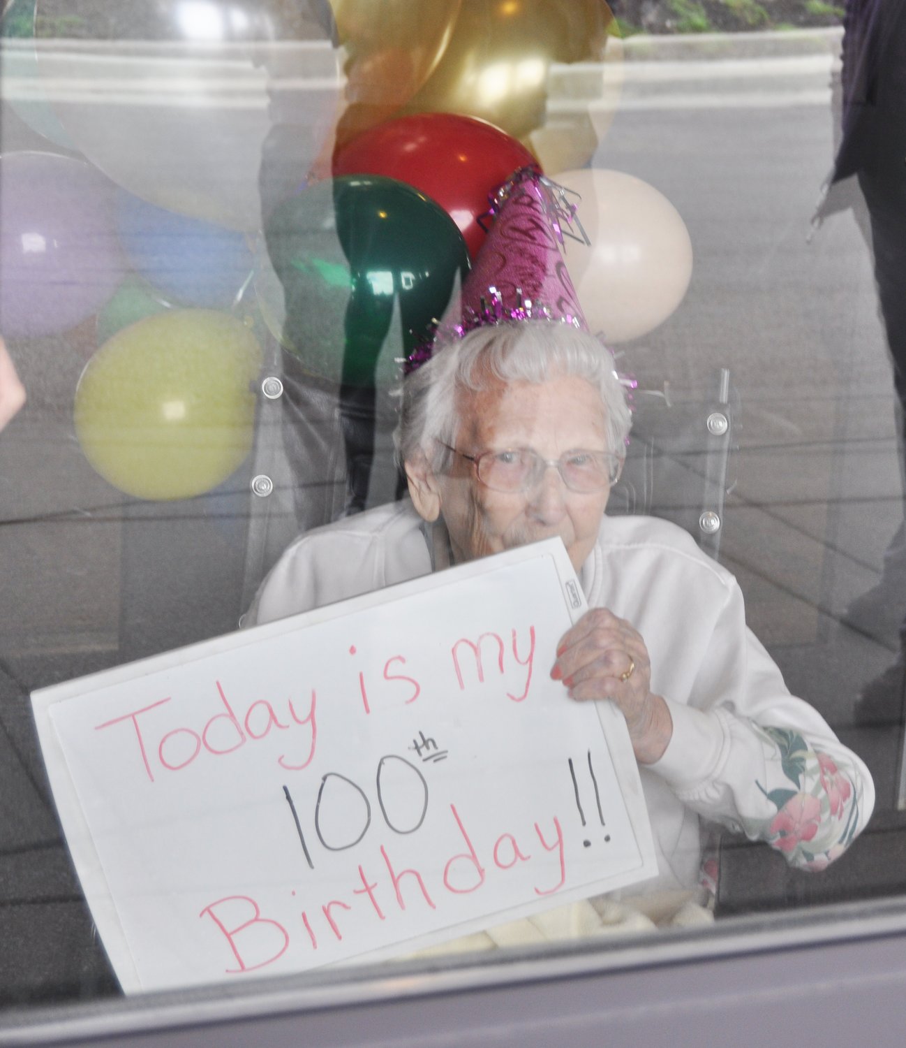 Jessie Grimes greets her children and their wives Thursday from the doors of Wellbrooke of Crawfordsville. Grimes was celebrating her 100th birthday.