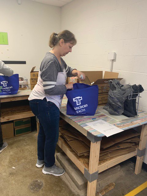 Cathy Kruse packs a bag of food for the Montgomery County Youth Service Bureau's Nourish program. The program was among local nonprofits receiving emergency funds from the Montgomery County Community Foundation. The bags were provided by Franciscan Health.