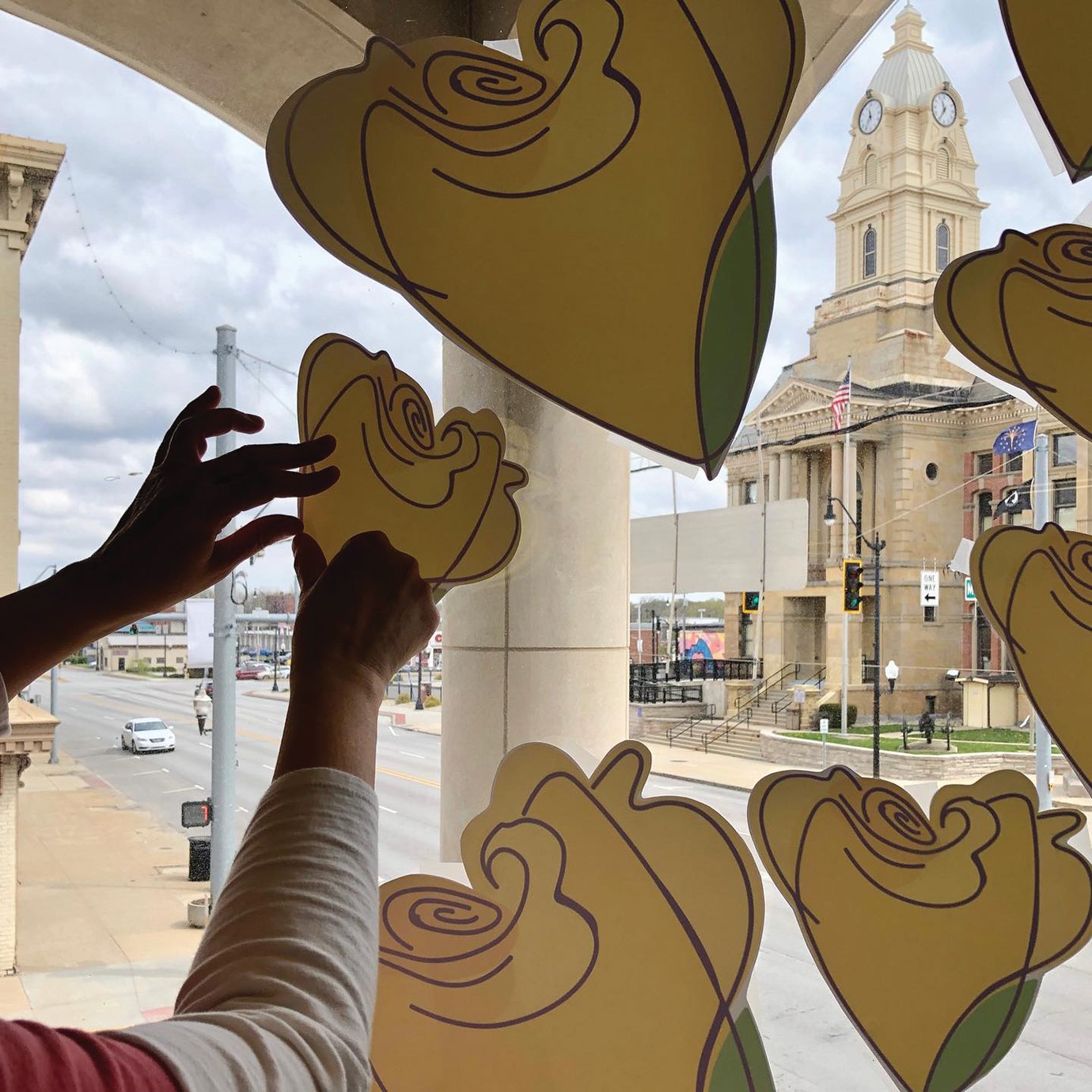 Yellow roses, which traditionally symbolize friendship, are installed on the second floor of the Fusion 54 building to show support for local businesses during times of crisis.