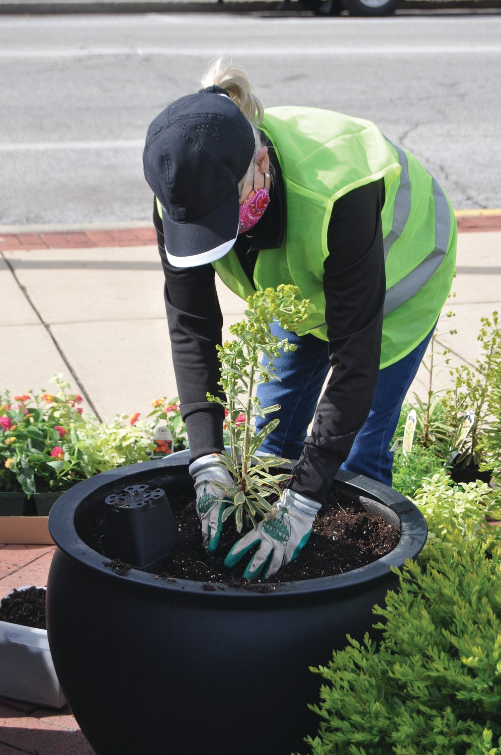 Belinda Kiger arranges a plant in a planter Monday at Marie Canine Plaza. Crawfordsville Main Street members planted flowers in the plaza.