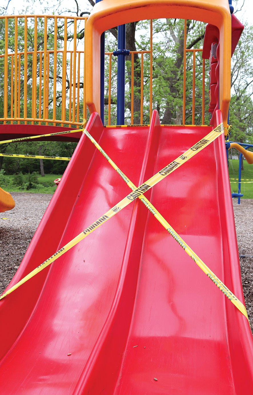 Slides, swing sets and other playground equipment stand dormant under caution tape Monday at Milligan Park. Though most park services have reopened, high-contact equipment such as playgrounds remained off limits until further notice.