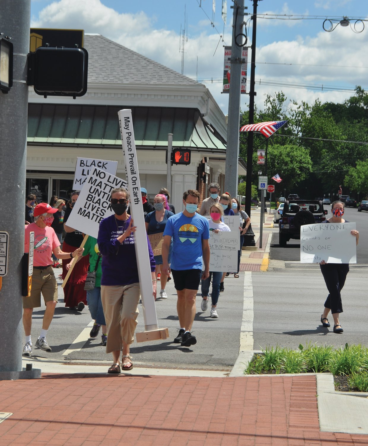 Kay Nannet, front, carries a peace pole at the head of a march for peace and equality Saturday in downtown Crawfordsville. The event was organized by Humans United for Equality and Voices for Peace.