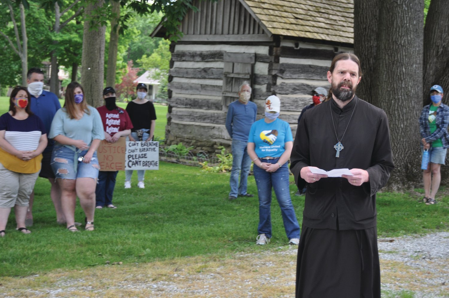 Fr. Joel Weir of St. Stephen the First Martyr Orthodox Church speaks to marchers gathering Saturday at Speed Cabin for the March for Peace and Equality. The event was organized by Humans United for Equality and Voices for Peace.