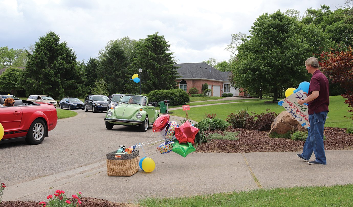 Well wishers stream past the home of retiree Larry Hutchison on Wednesday to honor his 45 years in the education system.