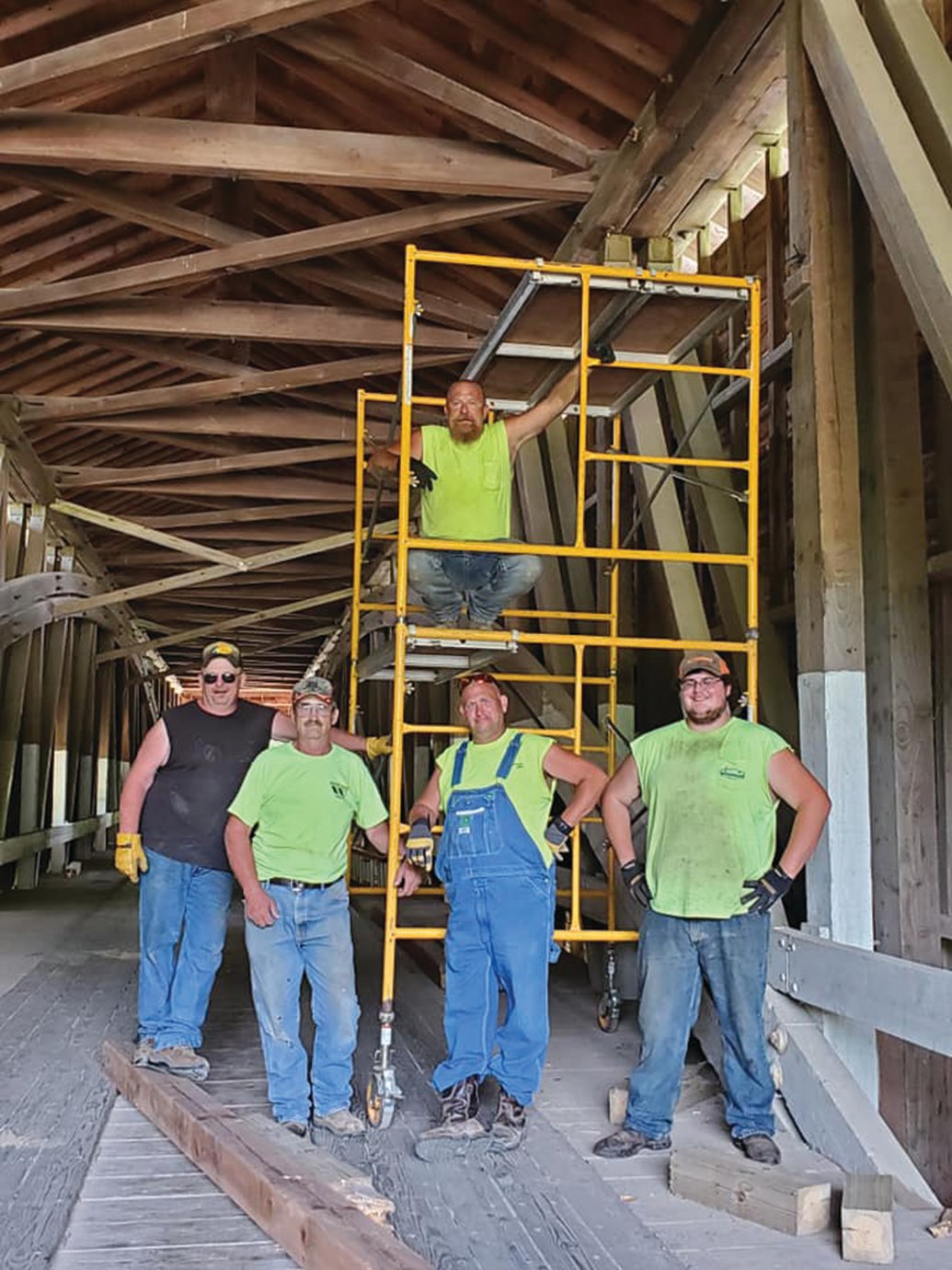 Parke County Highway Department workers Scott McMaster, top, and Buck Vandivier, from left, Wesley Garrett, Mike Wood and Jacob Cole make repairs to Jackson Bridge in Parke County on Saturday to alleviate traveling concerns between Rockville and areas north of the county.