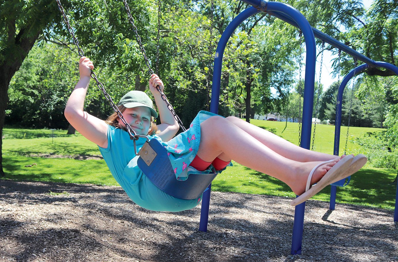 Ariel Drolinger puts the swings at Milligan Park to good use Friday as playground equipment is reopened.