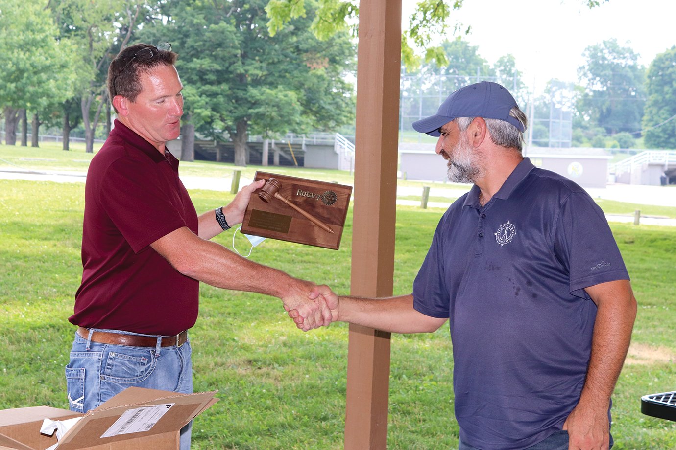 Former Rotary Club president Aaron Morgan, left, presents a plaque to outgoing president Roger Azar for his service at Milligan Park on Wednesday.