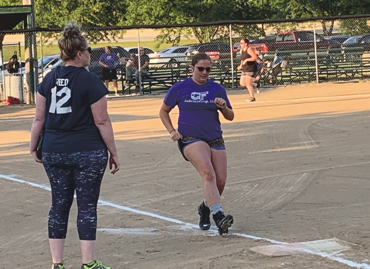 Sam Pigg heads to first base for C&F Fabricating early in the championship game of the Women's City Tournament under the watchful eyes of first base coach and pitcher Leah Reed. C&F defeated Gould/Stephenson/C&F to win the title, which came after they won the regular season championship.
