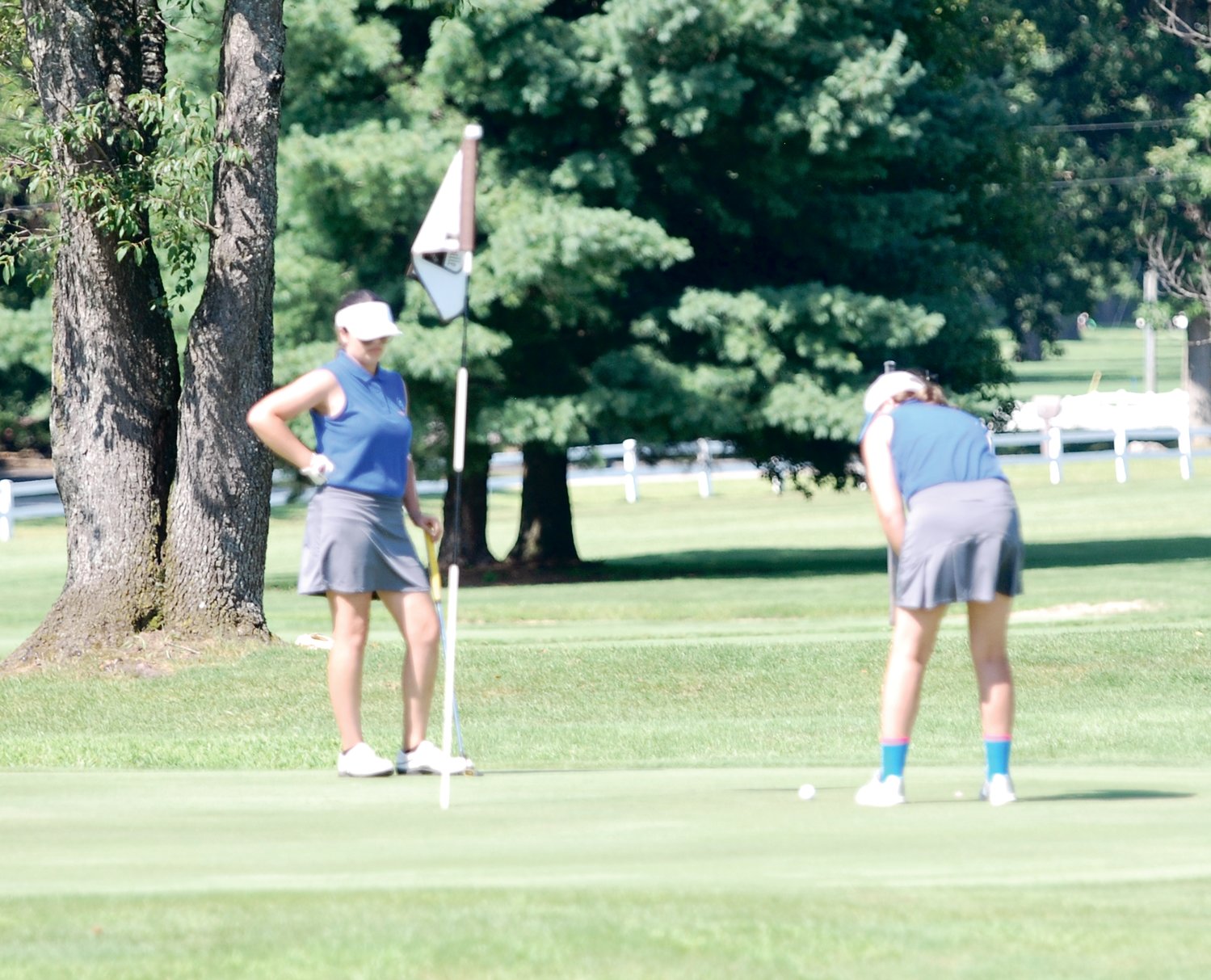 Crawfordsville's Gwyn Redding putts on No. 16 at the Crawfordsville Country Club Saturday afternoon as her sister, Evie Redding looks on. The duo helped the Athenians to a sixth-place finish at the Southmont Invitational.