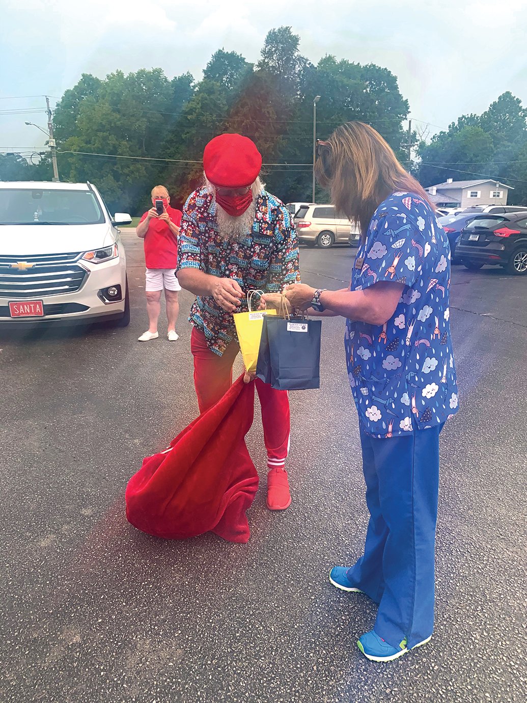 Crawfordsville Kiwanis incoming president and Santa for the day Gary Behling delivers handsoap to Hose Elementary nurse Kelly Harmon on Monday on behalf of the club.