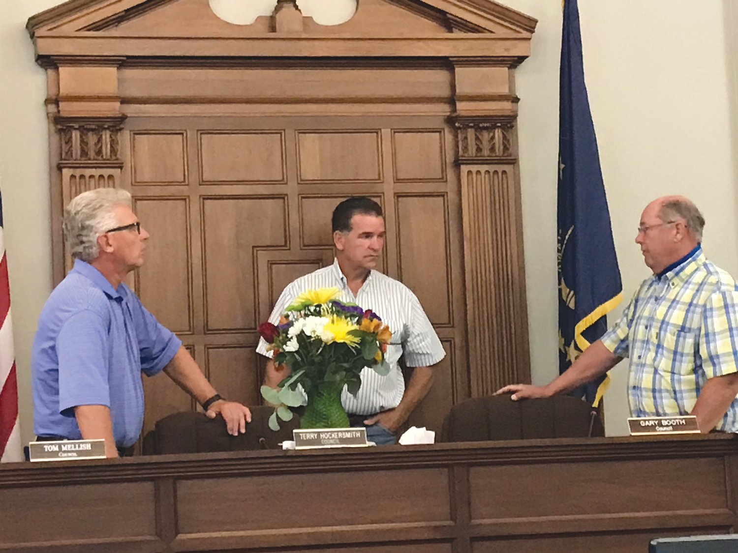 Montgomery County Council members, from left, Tom Mellish, Mark Smith and Gary Booth have a conversation before Tuesday's meeting in the City Building. The bouquet of flowers marked the seat of council president Terry Hockersmith, who died Thursday.