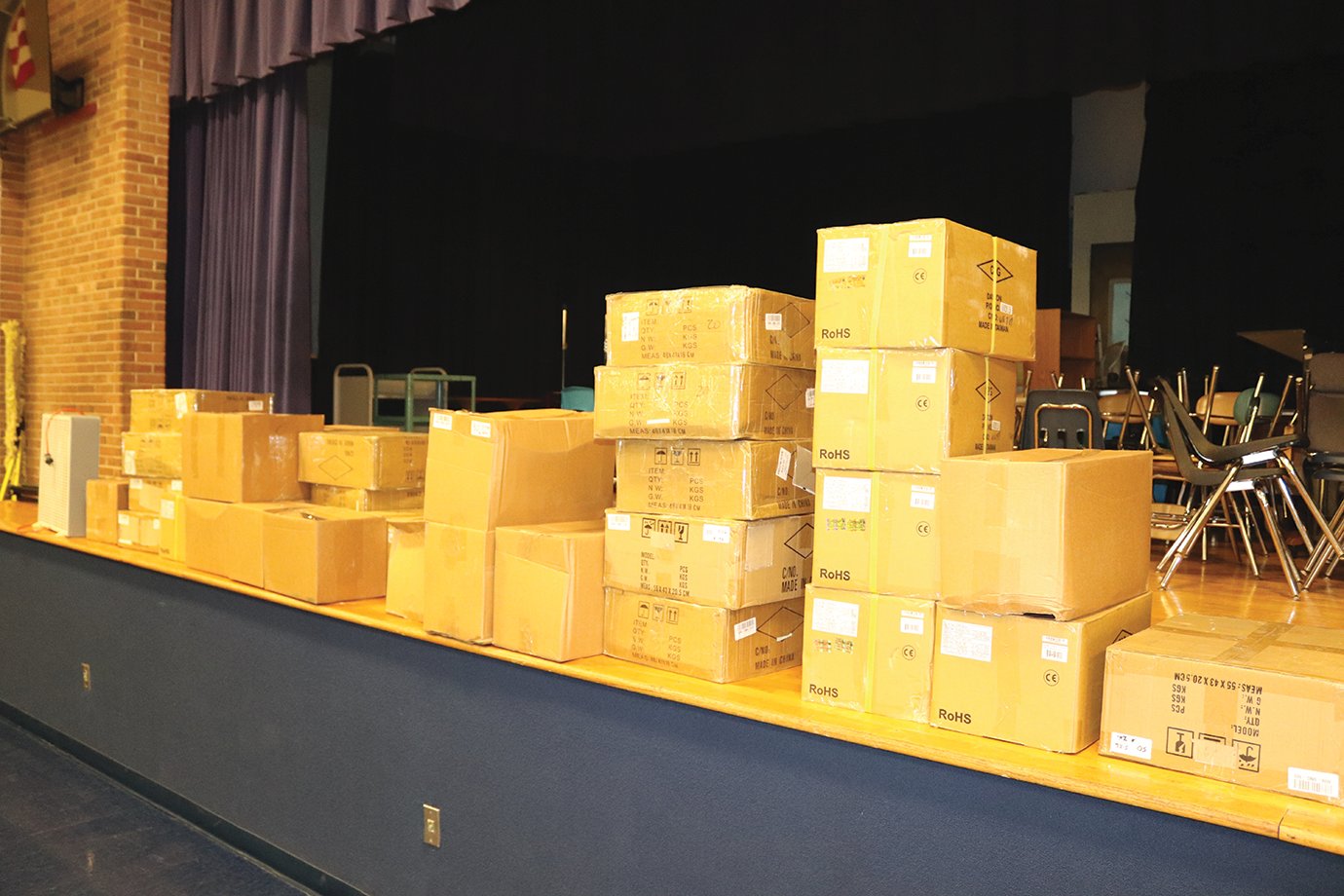 Boxes containing new Google Chromebooks wait to be opened in the cafeteria at Fountain Central Jr.-Sr. High School for those who signed up for online learning courses.