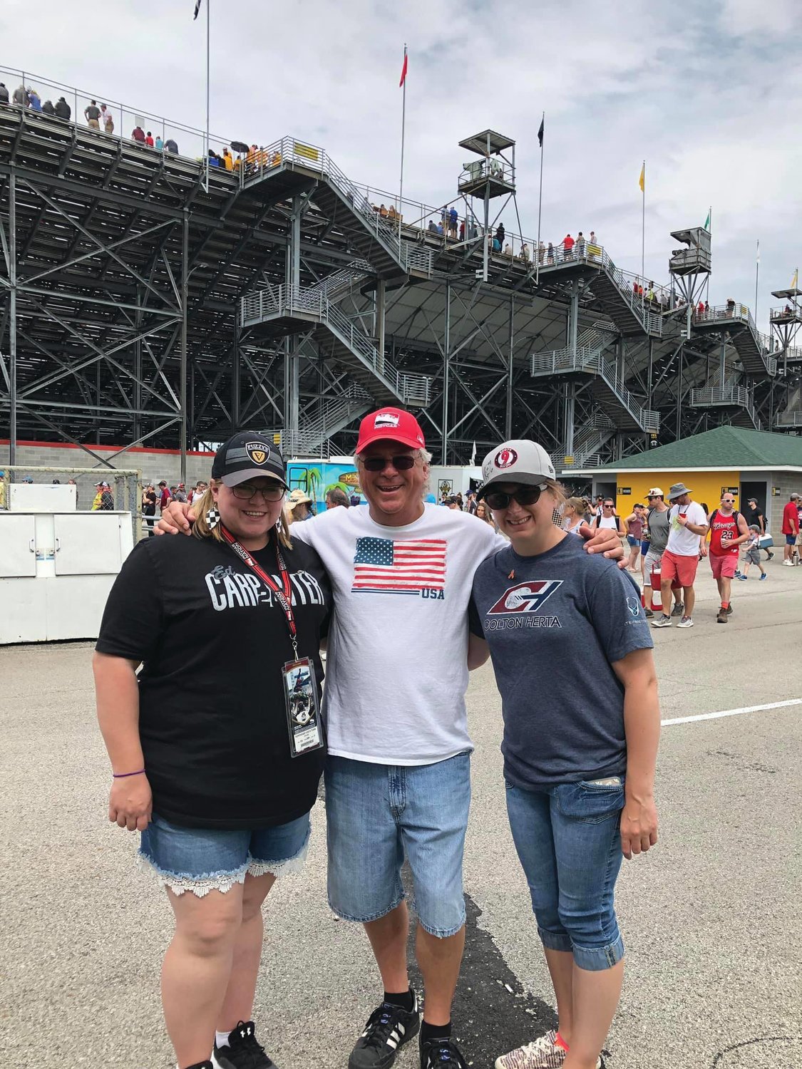 Chelsea Ebaugh, left, stands at the Indianapolis Motor Speedway with her father, Mike, and sister, Bailey. The longtime race fans will watch this year's Indianapolis 500 on television after the track was closed to fans.
