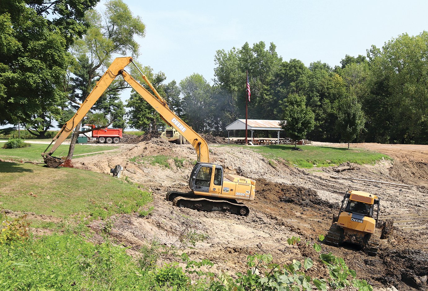 Crews work with heavy equipment Tuesday to remove silt from the pond at the Darlington Conservation Club. When the project is complete, the pond will be roughly five feet deeper than before and restocked with game fish.