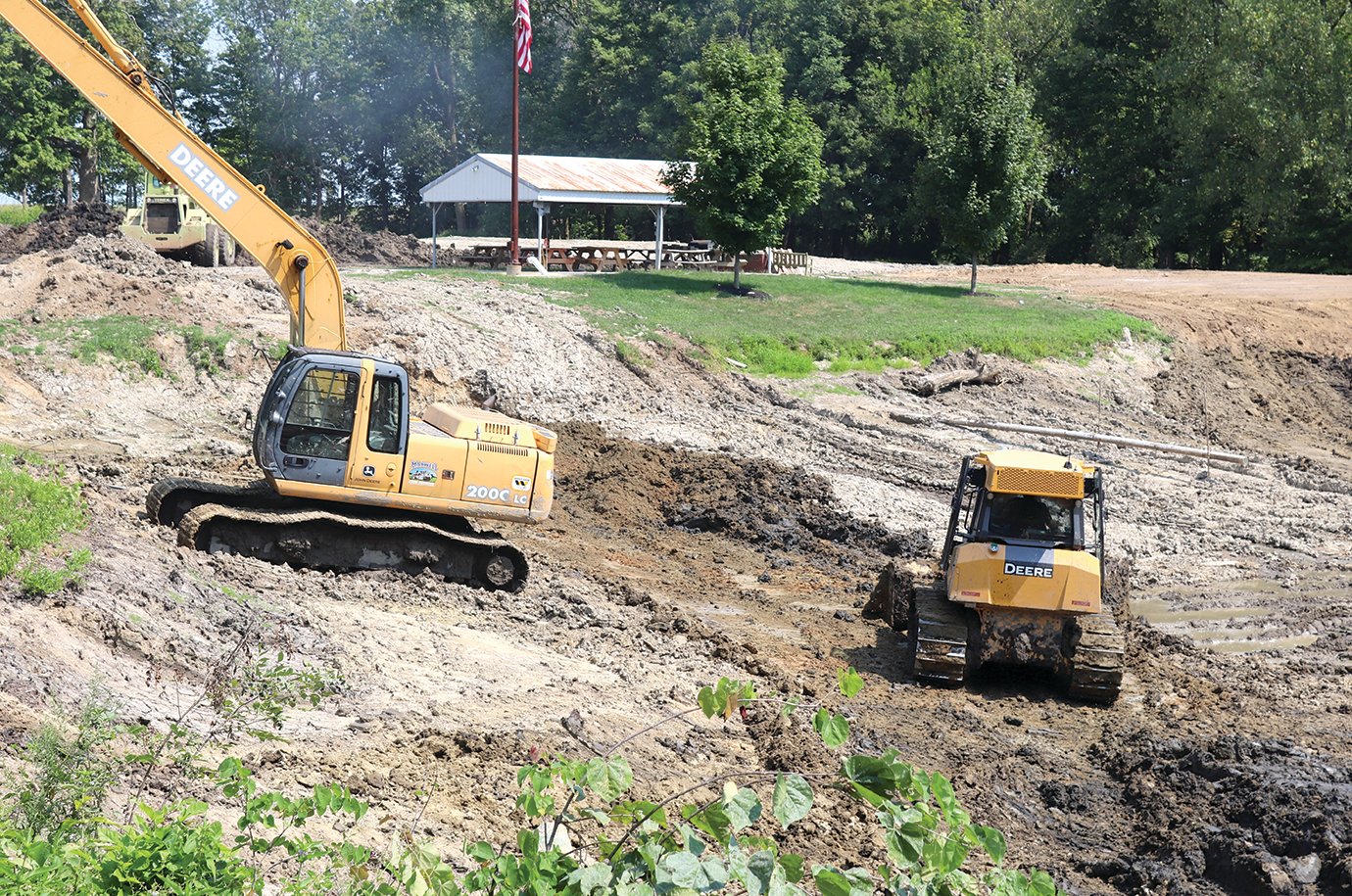 Mud and silt are removed fron the Darlington Conservation Club pond Tuesday by heavy equipment donated by Bart Maxwell of Maxwell Trucking & Excavating for the project.