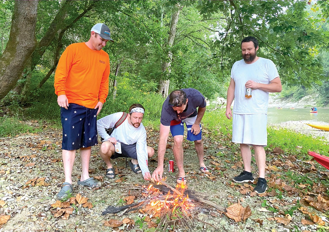 A group of kayakers builds a fire on the banks of Sugar Creek this Labor Day Weekend, making the best of the morning rain. Several caught in inclement weather on the creek Sunday were warmed by the comaraderie and impromptu fire created by Tom McClamroch, from left, Levi Hession, Mitch Barker and Jeremiah Brown.