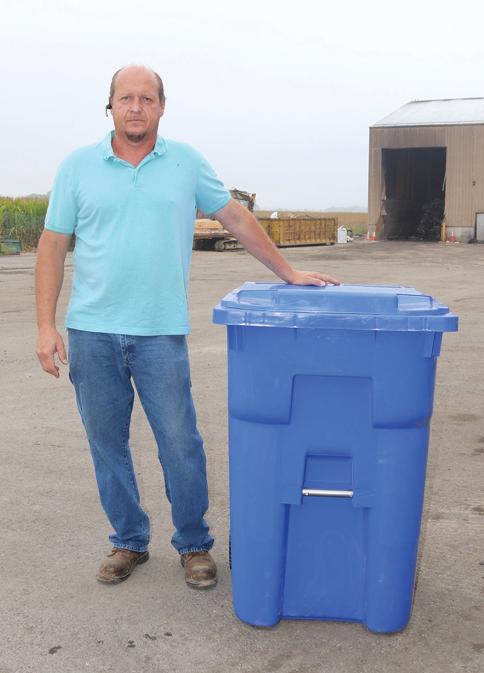 Sam Newlin, proprietor of T&S Trash Service, shows off the new design of his company's trash cans, also known as "toters," which are designed to be used with a fully automated trucks. The toters, to be painted brown, are reinforced in areas where the automated "arm" makes contact with the can, and feature a metal crossbar for extra grip. The 95-gallon, redesigned cans are shorter and wider than their predecessors to allow more room for waste and ease of use.