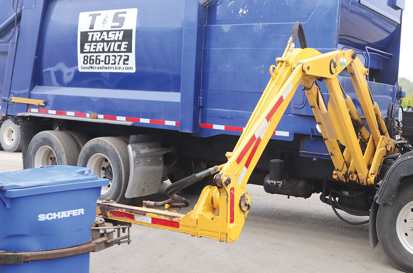 A fully-automated arm attached to a new T&S Trash Service truck performs its duties Thursday.