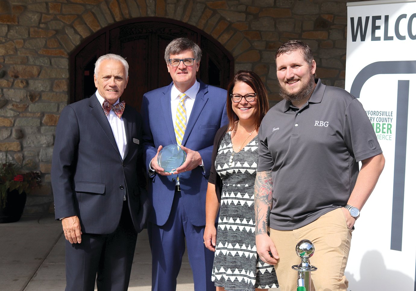 Dave Long, from left, Dave Peach, Jami Harrington and Travis Harrington walk the green carpet Sept. 3 after receiving and presenting, respectively, the Chamber of Commerce award for Small Business of the Year at the Crawfordsville Country Club.