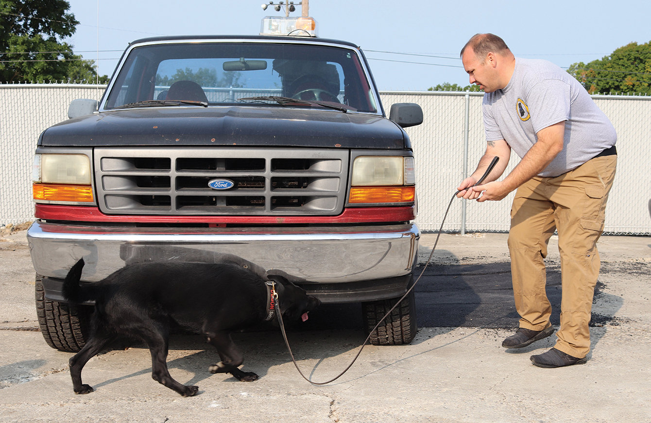 Sergeant Kevin Crull and K9 Officer Demon of the Montgomery County Sheriff's Office sweep a vehicle for drugs Tuesday during training session at 1201 Elmore St. K9 officers and their partner handlers from across the Midwest converged on Crawfordsville this week for the North American Police Work Dog Association's annual week-long certification mission.