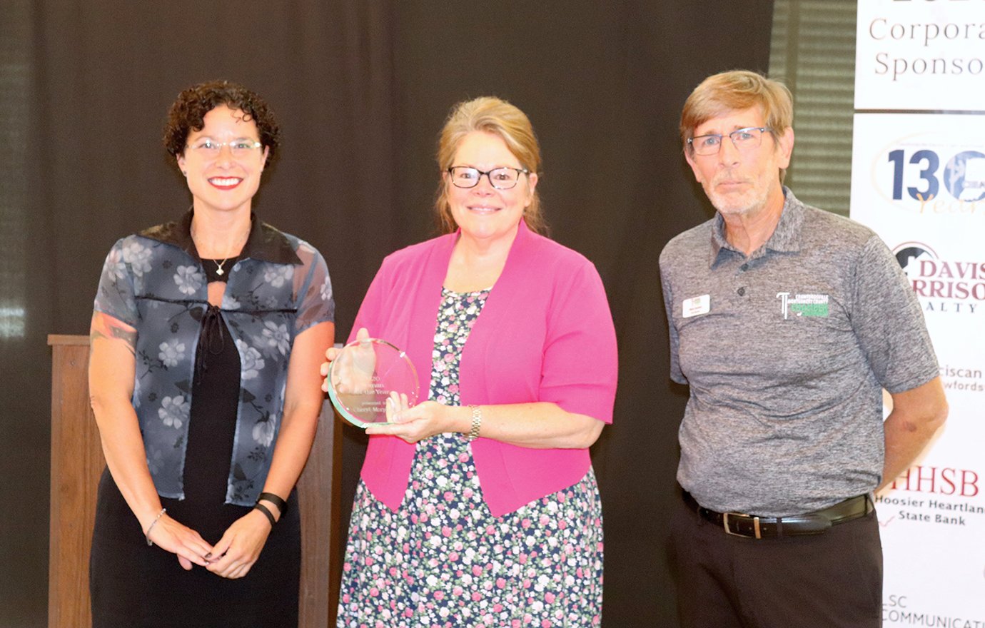 The Chamber of Commerce Woman of the Year, Cheryl Morphew, center, accepts her award Sept. 3 at the Crawfordsville Country Club alongside Chamber board of directors president Tracy Mobley, left, and Carpenter’s Realtors branch manager and agent Steve Zachary.