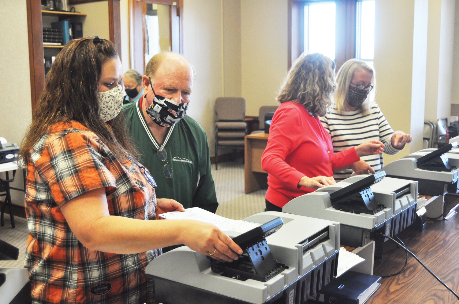 Voter Registration Clerk Leah Denbo, first from left, inserts a ballot into a tabulation machine as Republican Election Board member Daryl Livesay looks on and equipment representative Janet Buchanan and Clerk Karyn Douglas test other machines Friday at the Montgomery County Courthouse.