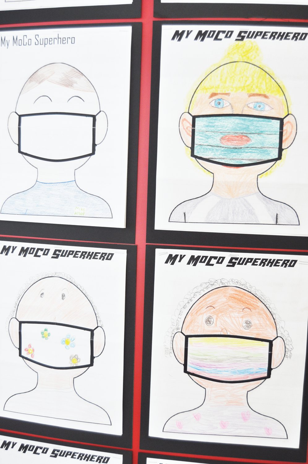 Pictures of "MoCo Superheroes" drawn by children are displayed at the Carnegie Museum of Montgomery County. The pictures are part of an exhibit documenting children's voices in the coronavirus pandemic.