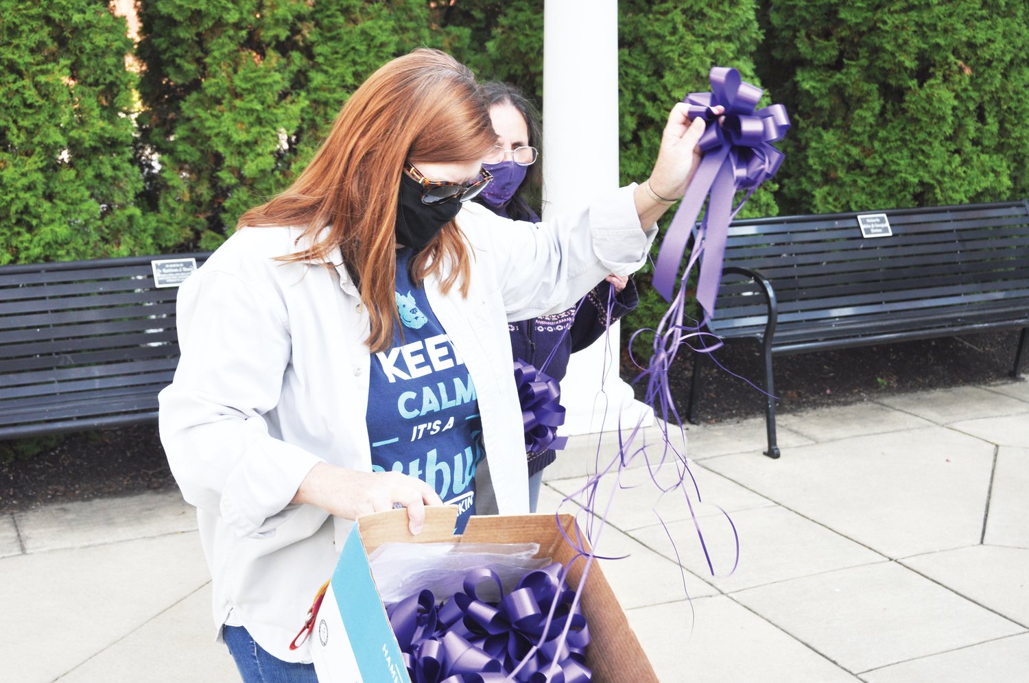 Deb Lee, an employee of the Family Crisis Shelter, takes a purple ribbon out of a box to hang in Marie Canine Plaza Tuesday, as co-worker Kathy Walker looks on. The shelter tied ribbons throughout downtown in observance of Domestic Violence Awareness Month. While the number of clients in the shelter's residential services has declined this year, the use of some outreach programs has quadrupled during the coronavirus pandemic, executive director Anita Byers says. Advocates are using the month to promote resources available to domestic violence survivors. The shelter's 24-7 hotline is 765-362-2030 or 800-370-4103.