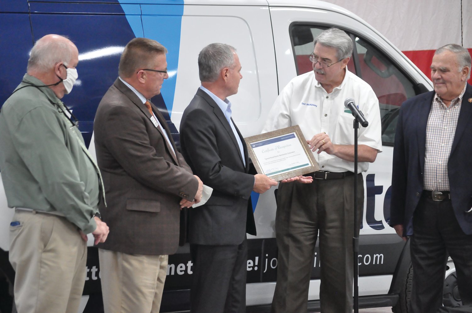 Ted McKinney, undersecretary of agriculture for trade and foreign agricultural affairs, presents a certificate of recognition to Tipmont REMC CEO Ron Holcomb as dignitaries look on Wednesday near Kingman. Tipmont/Wintek received more than $1 million in federal matching funds to expand high-speed internet to additional homes, farms and businesses in Fountain County.