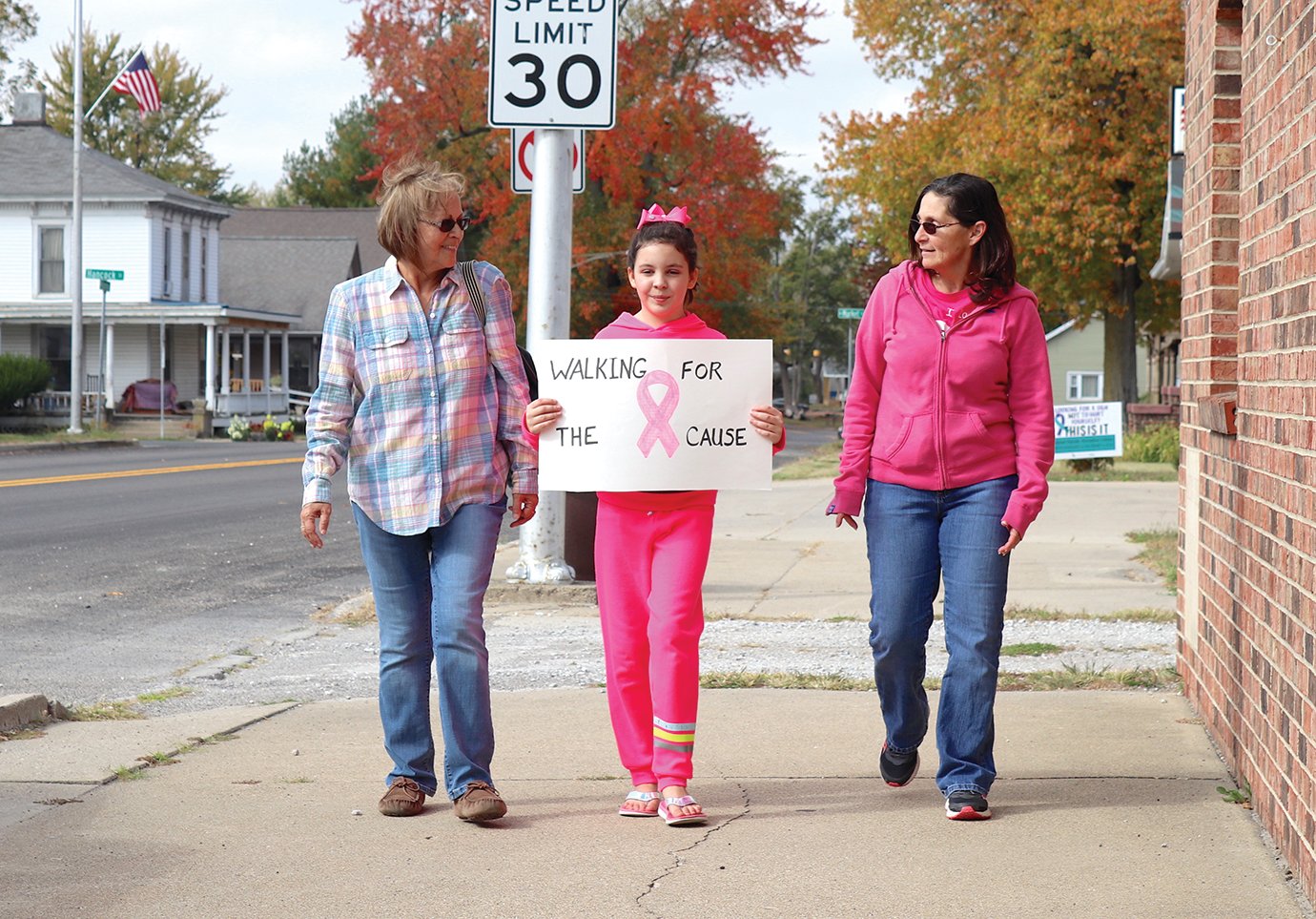 Nancy Gregg, from left, 11-year-old Brylee Dinius and grandmother Christa Dinius create a Breast Cancer Walk of their own along Washington Street in Waynetown. The group's impromtu decision follows the cancelation of the walk of the same name in Indianapolis each October, thwarted this year by the coronavirus (COVID-19).