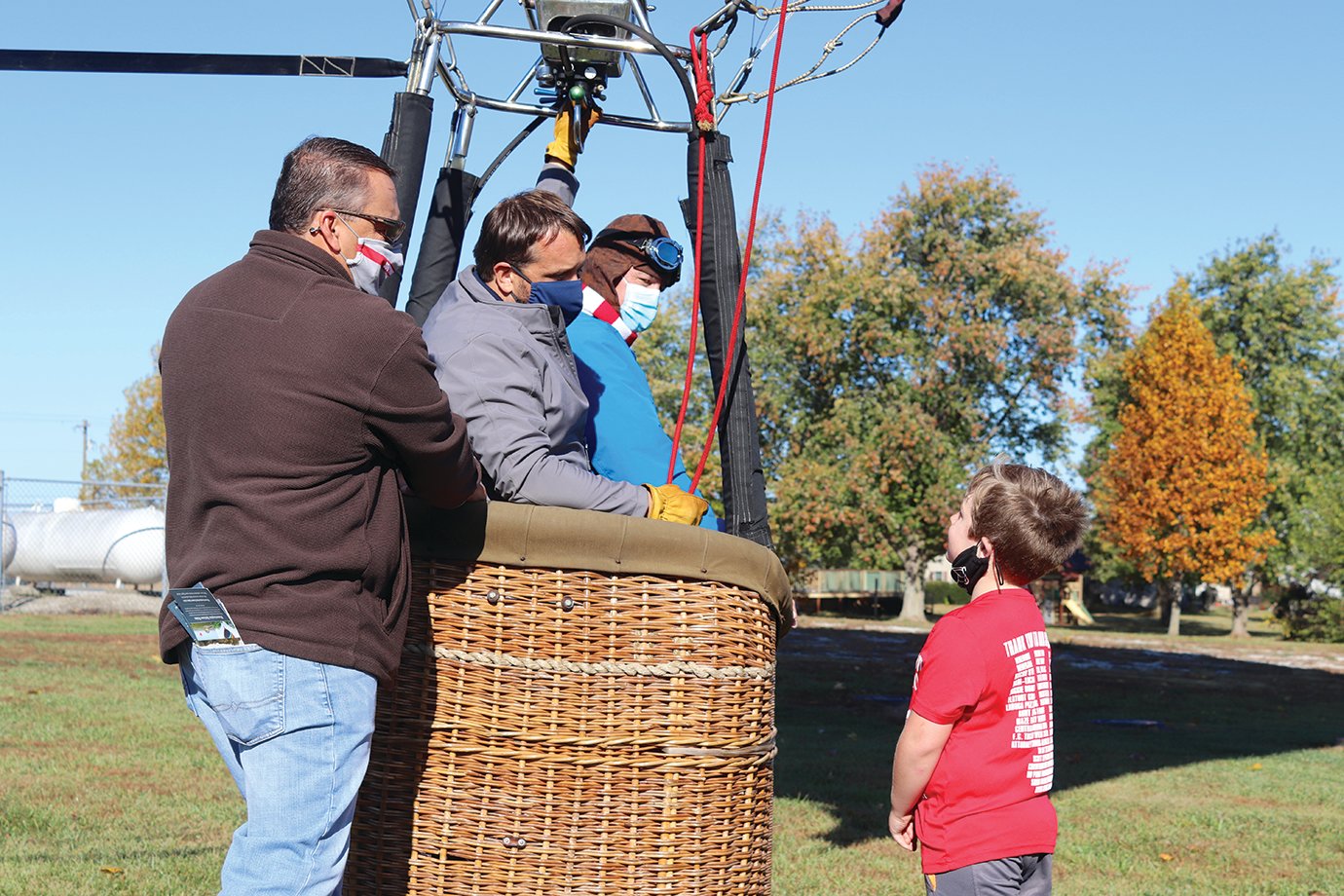 Walnut Elementary second-grade student Kaydenn Weaver asks South PTO President Todd Douglas, from left, Bloomington Balloon Rides owner Andy Richardson and Principal Eric Brewer just how big the hot air balloon might be.