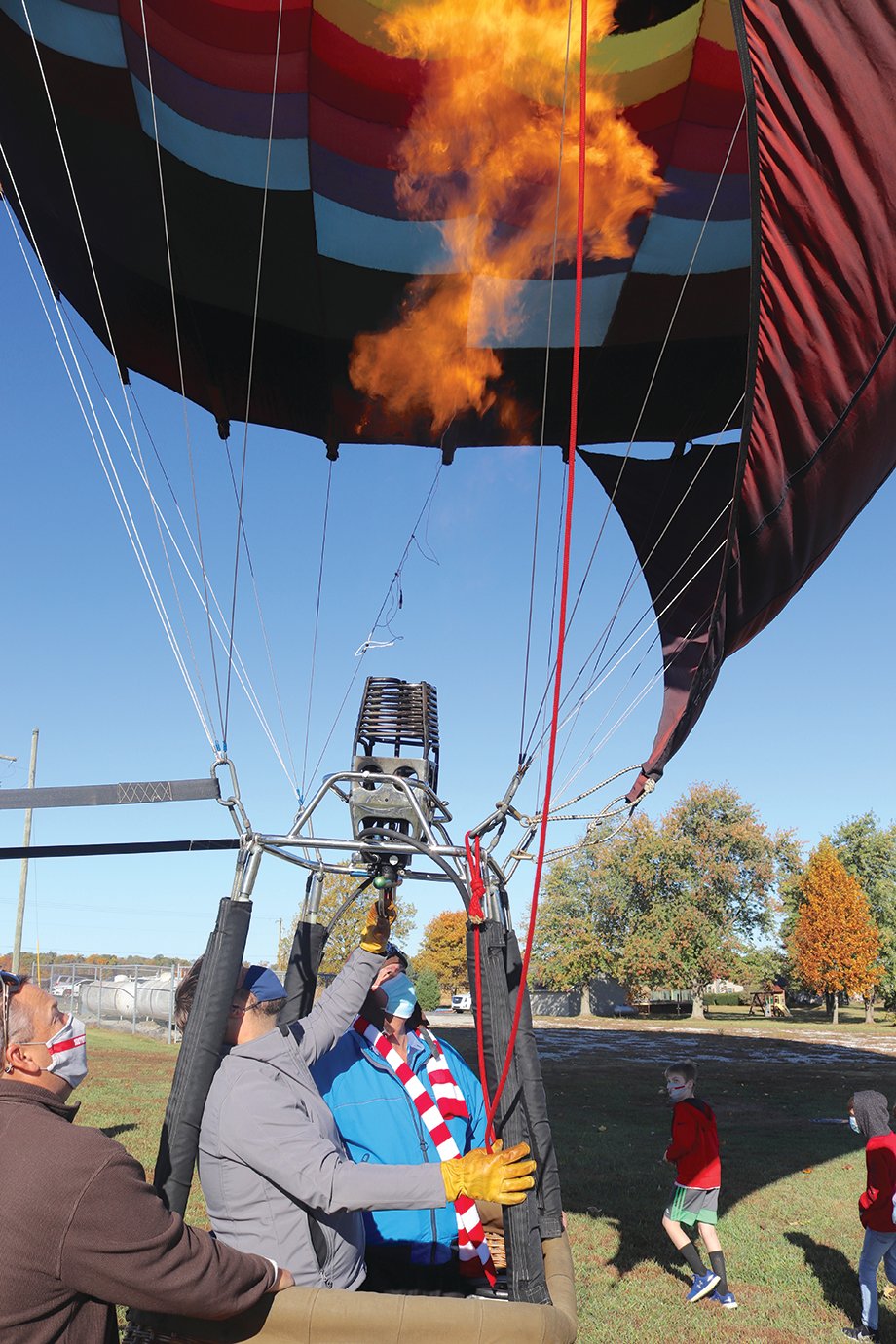 South PTO President Todd Douglas, from left, Bloomington Balloon Rides owner Andy Richardson and Walnut Elementary Principal Eric Brewer fire up the hot air balloon Tuesday at the southeast county school.