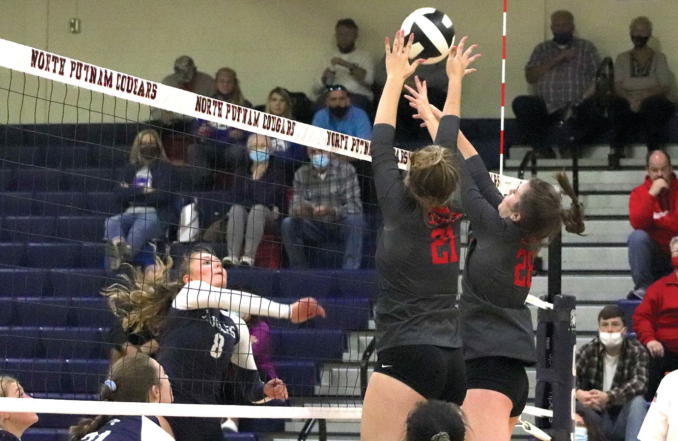 Sophomore Dara Watson and freshman Chelsea Veatch block a spike from North Putnam junior Haley Dickson.