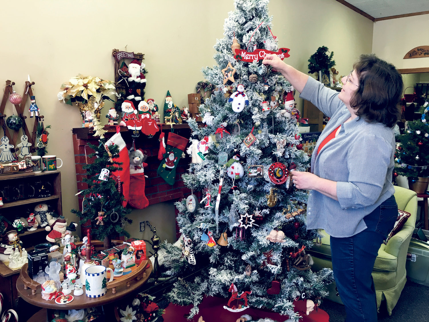 Jutta Hutson decorates a donated Christmas tree with donated ornaments in the La Rose Christmas Shop.