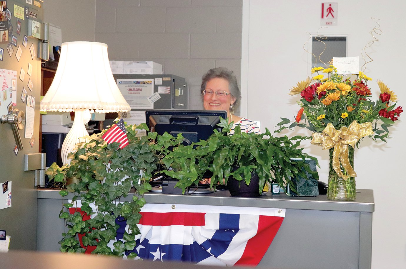 Jennifred Jones sits surrounded by donated decorations in her office at the Wingate Post Office Thursday.