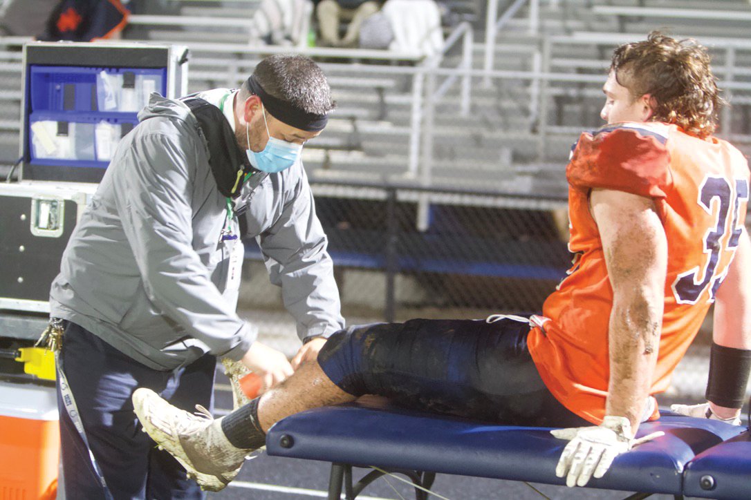 North Athletic Trainer Isaac Hook retapes senior Jacob Braun to get him back into the game..