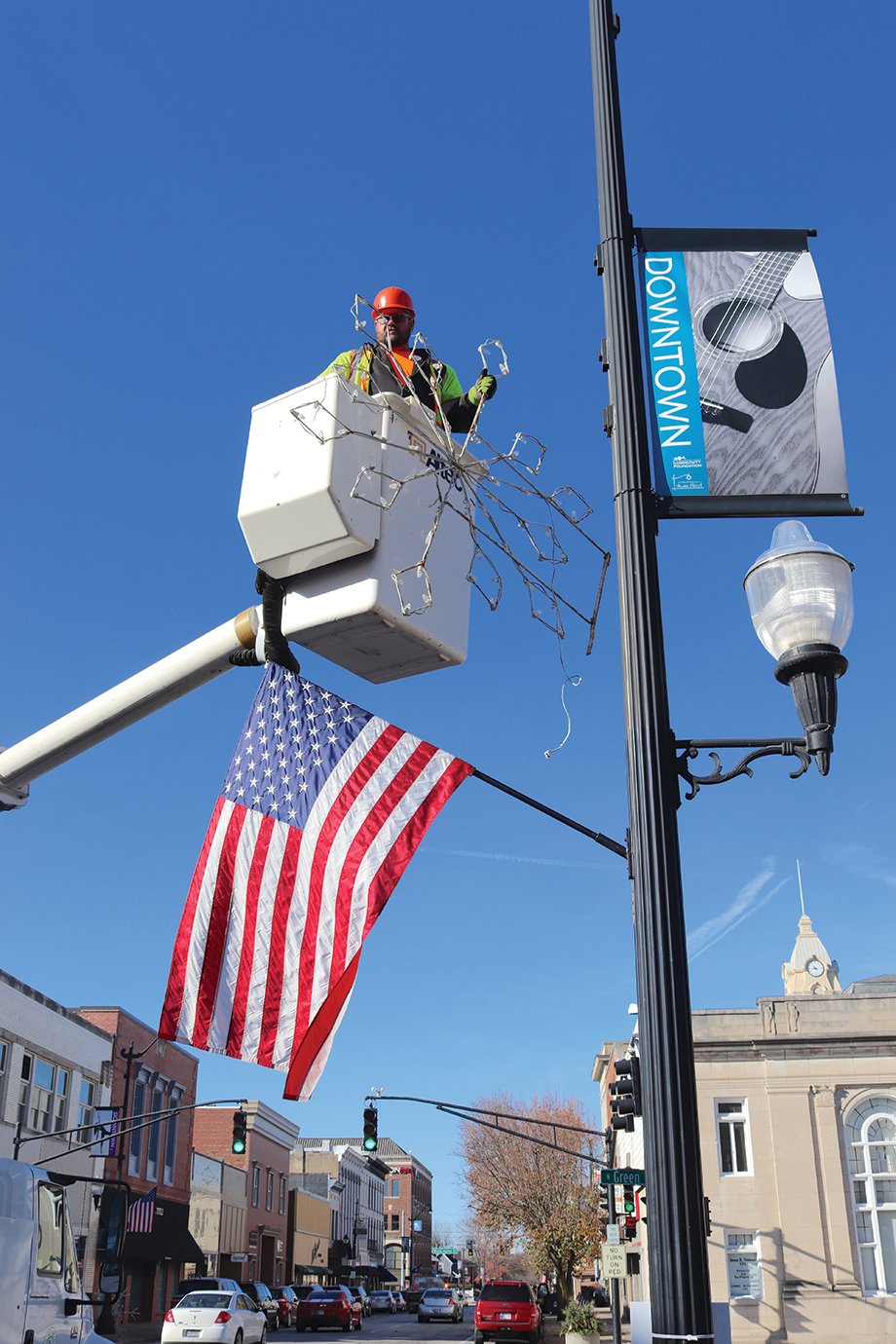 Snowflakes and other city-sponsored decorations add holiday cheer downtown Crawfordsville, exemplified Tuesday by Street Department crew member Tom Edwards.