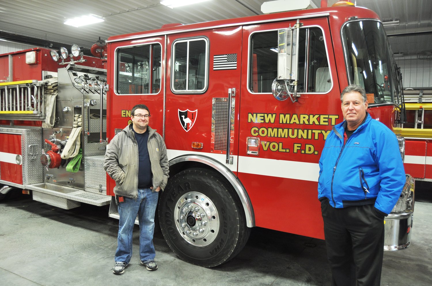 Dan Keller, left, New Market Community Volunteer Fire Department chief, and board president Eric Brewer stand next to an engine donated by a department in Connecticut.