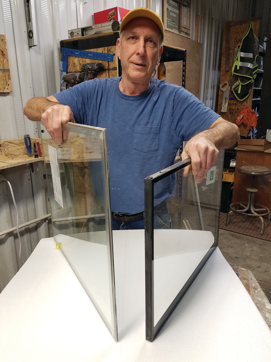 Bill Hepburn of Heirloom Windows is holding two pieces of insulated glass to show the differences.  The one on the left is vacuum insulated glass (VIG) and is 1/4
