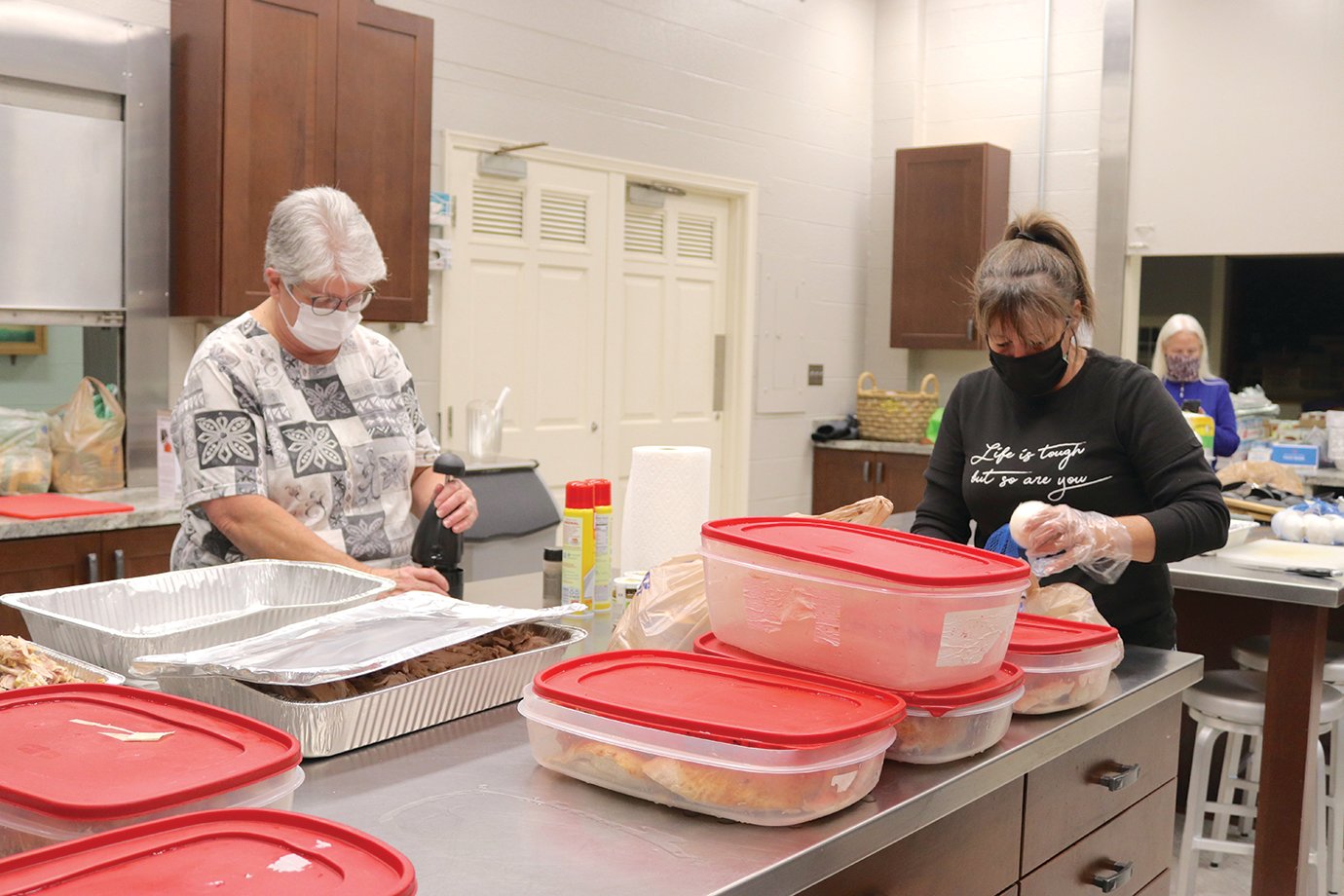 Thanksgiving Community Dinner volunteers Deb Corey, left, and Stephanie Hale prepare vast amounts of turkey, ham, mashed potatoes, homemade noodles, dressing, green beans with ham and onions, rolls, apple and cranberry sauce and desserts, mostly consisting of traditional holiday pies such as pumpkin and pecan.